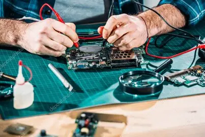Computer Service Technician working on computer at an electronics repair bench